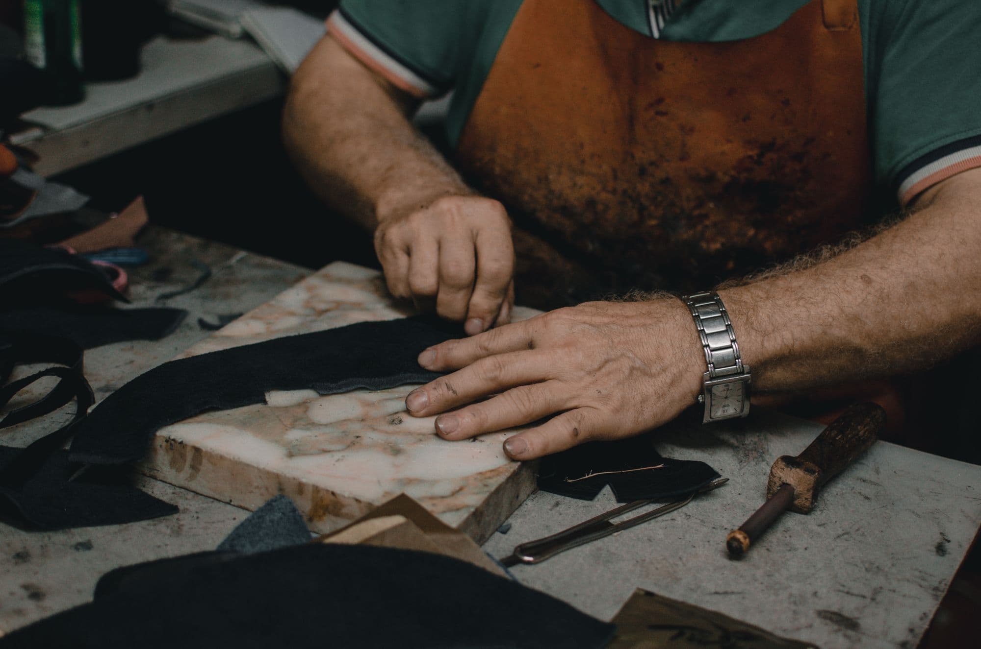 Artisan hand-cutting leather in the Frontier Shoes workshop